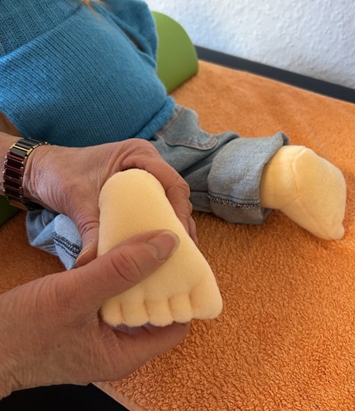 Friederike Schaeff behandelt den Fuß von Handpuppe Sam nach Zukunft-Huber.